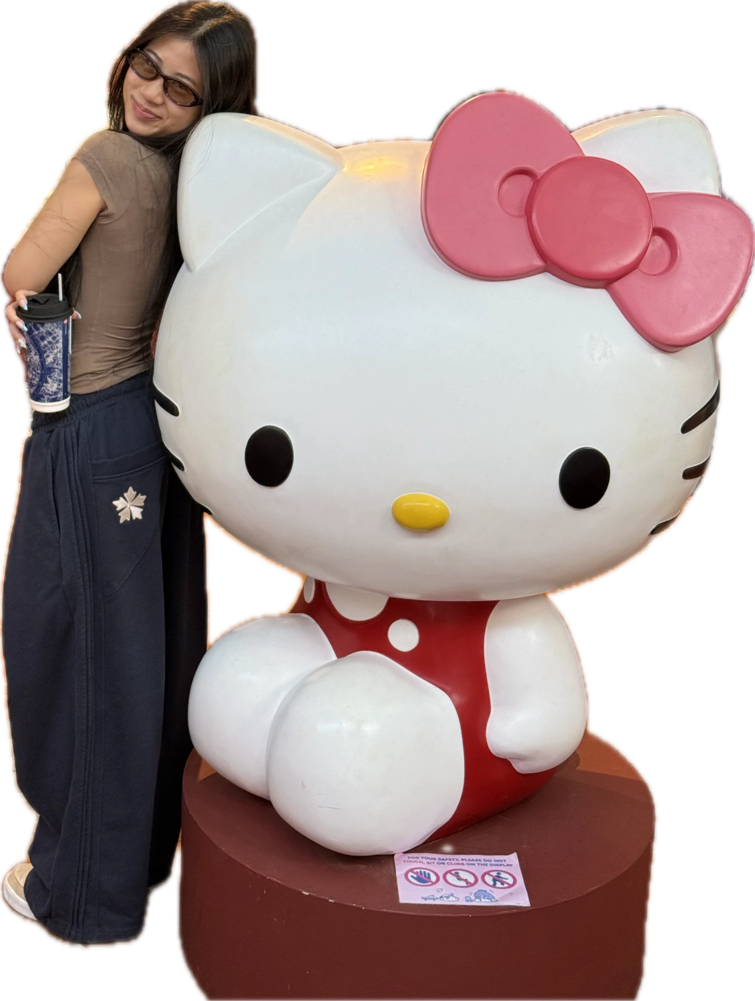 Thi hugging a giant Hello Kitty statue